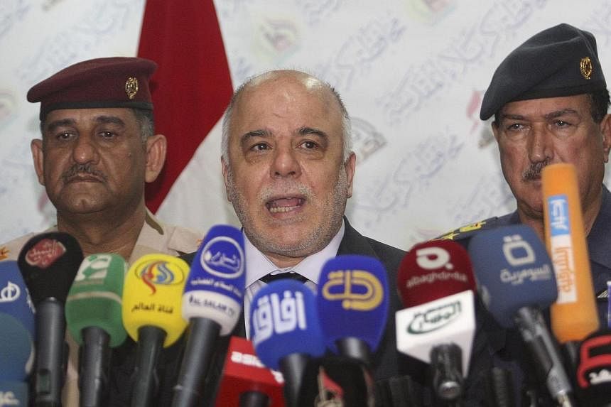 Iraqi Prime Minister Haider al-Abadi (centre) speaks at a news conference in Kerbala, southwest of Baghdad, on Dec 8, 2014.&nbsp;Iraq's Prime Minister pressed outgoing US Defence Secretary Chuck Hagel on Tuesday for more air strikes and weaponry to a