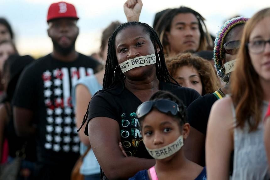 Demonstrators stand with tape reading, "I Can't Breathe", to protest police abuse on Dec 7, 2014 in Miami, Florida. A Florida sheriff has called for calm after a 28-year-old unarmed black man in a stolen car was shot and critically wounded early on M