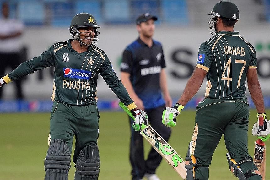 Pakistani batsman Haris Sohail (left) celebrates with teammate Wahab Riaz after playing a winning shot during the first Day-Night International cricket match to steer Pakistan to a three-wicket win over New Zealand in the first day-night internationa