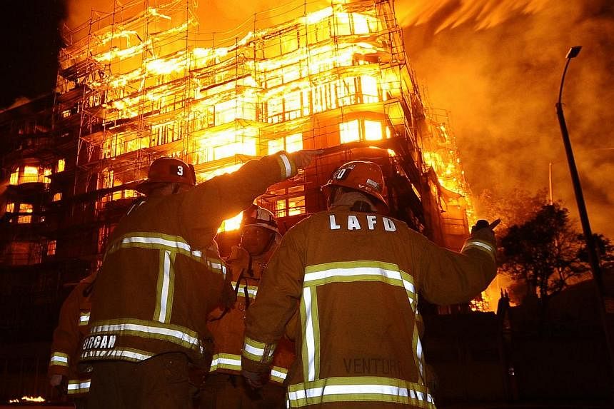 Los Angeles city firefighters battle a massive fire at a seven-story downtown apartment complex under construction in Los Angeles, California on Monday. More than 250 firefighters battle the early morning blaze which shutdown two major freeways the L