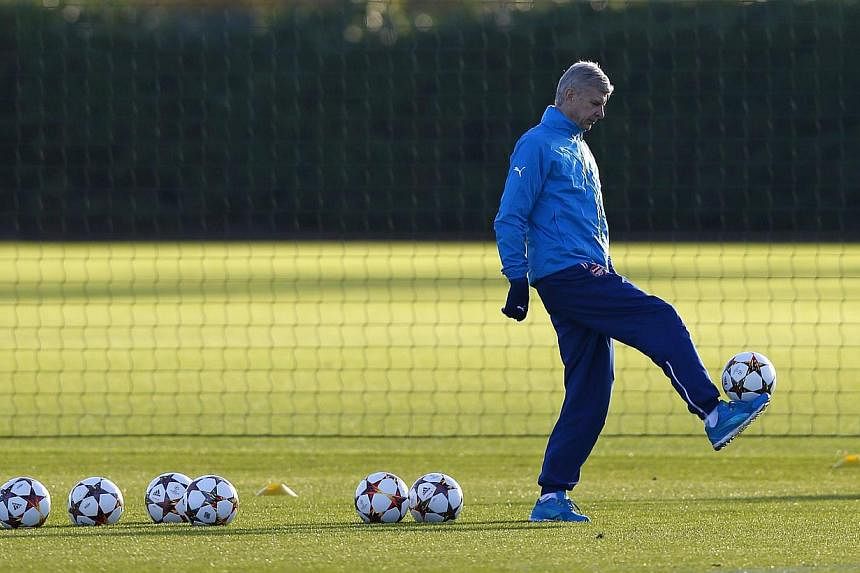 Arsenal manager Arsene Wenger controls a ball during a training session ahead of their Champions League soccer match against Galatasaray, at their training facility in London Colney, north of London on Monday. -- PHOTO: REUTERS