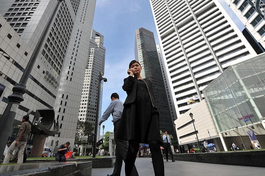 People walking outside Raffles Place MRT. More firms in Singapore are providing flexible work benefits for their staff, says the Manpower Ministry. -- PHOTO: ST FILE