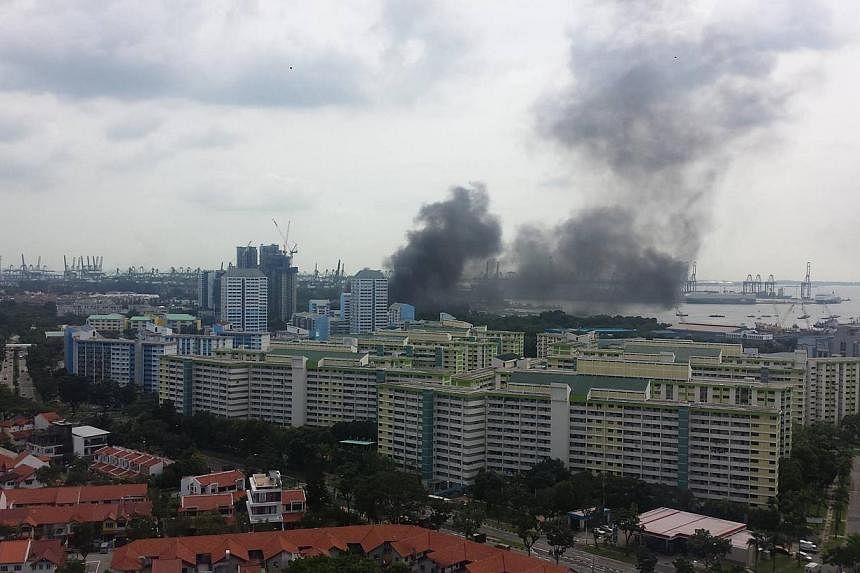 A thick, dark mass of smoke rising from the affected area at around 2.10pm, seen from a condominium in West Coast Walk. -- PHOTO: GEOFFREY DELHAYE
