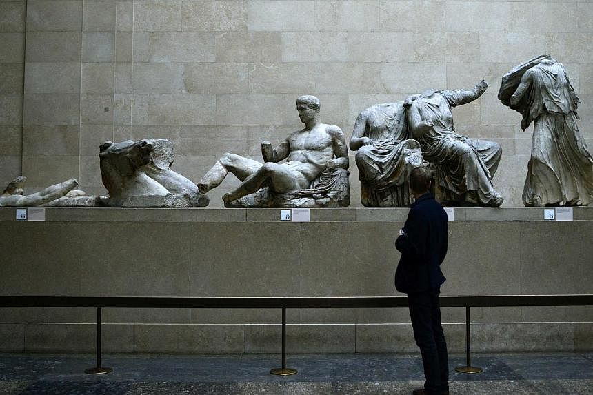 A man looks at the Parthenon Marbles, a collection of stone objects, inscriptions and sculptures, also known as the Elgin Marbles, on show at the British Museum in London on Oct 16, 2014. -- PHOTO: REUTERS