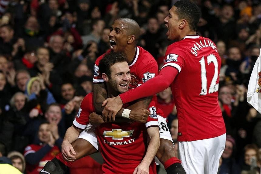 Manchester United's Juan Mata (centre) celebrates with Ashley Young and Chris Smalling (right) after scoring his team's second goal during their English Premier League soccer match against Stoke City at Old Trafford in Manchester, northern England, o