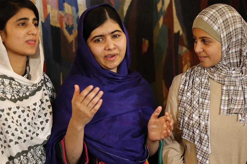 Nobel Peace Prize laureate Malala Yousafzai (centre) being flanked by Sahazia Ramzan (left) of Pakistan and Mezon Almellehan of Syria, young women activists Malala invited to accompany her in Oslo on &nbsp;Dec 9, 2014. -- PHOTO: REUTERS