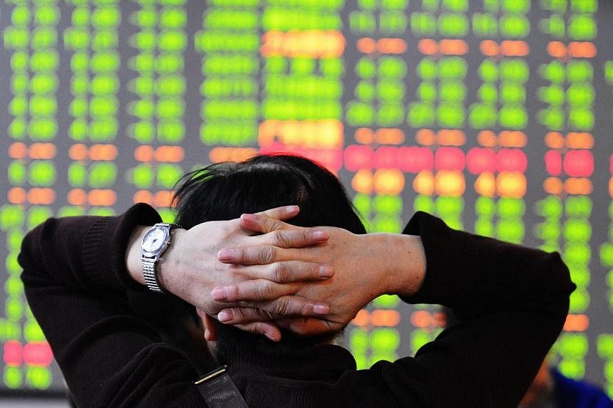 A stock investor checks the share prices at a security firm in Hangzhou, east China's Zhejiang province on Dec 9, 2014.&nbsp;Investors sold equities worldwide on Tuesday after China's market posted its worst day in five years and oil prices fell to l