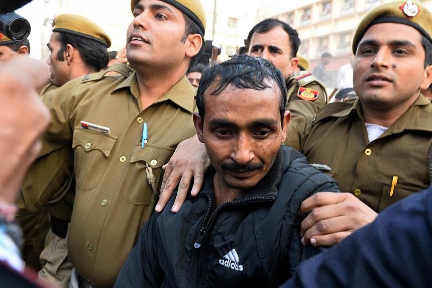 Indian police escort Uber taxi driver Shiv Kumar Yadav (centre), who is accused of rape, following his court appearance in New Delhi on Dec 8, 2014. -- PHOTO: AFP