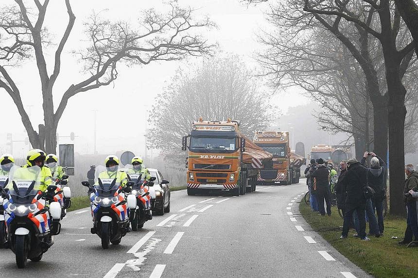 Trucks carrying wreckage from Malaysia Airlines flight MH17 arrive at a Dutch airforce base in the southern town of Gilze-Rijen Dec 9, 2014. Trucks carrying wreckage from Malaysia Airlines flight MH17 crossed into the Netherlands overnight where inve