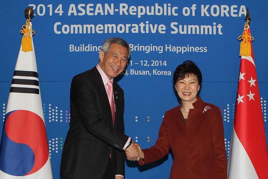 South Korea's President Park Geun Hye (right) shakes hands with Singapore's Prime Minister Lee Hsien Loong during their bilateral meeting at the Asean-Republic of Korea Commemorative Summit in Busan on Dec 11, 2014.&nbsp;PM Lee and President Park rea