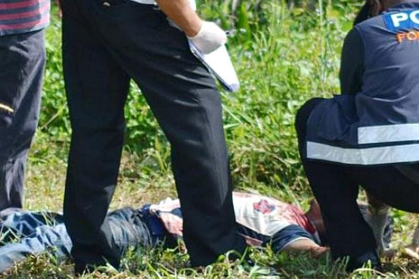 Policemen at the scene of the murder of construction worker Hein Lat Kyaw in Butterworth, Penang. His body was found in an oil palm estate by a passer-by, who alerted the police at about 8.30am on Nov 11, 2014.&nbsp;-- PHOTO: THE STAR/ASIA NEWS NETWO