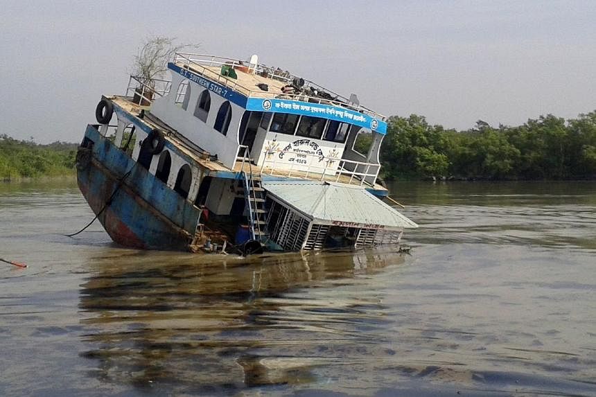 A Bangladeshi oil tanker lies half-submerged after it was hit by a cargo vessel on the Shela River in the Sundarbans in Mongla on Dec 9, 2014.&nbsp;Bangladesh officials warned Thursday, Dec 11, that the oil spill &nbsp;is threatening endangered dolph
