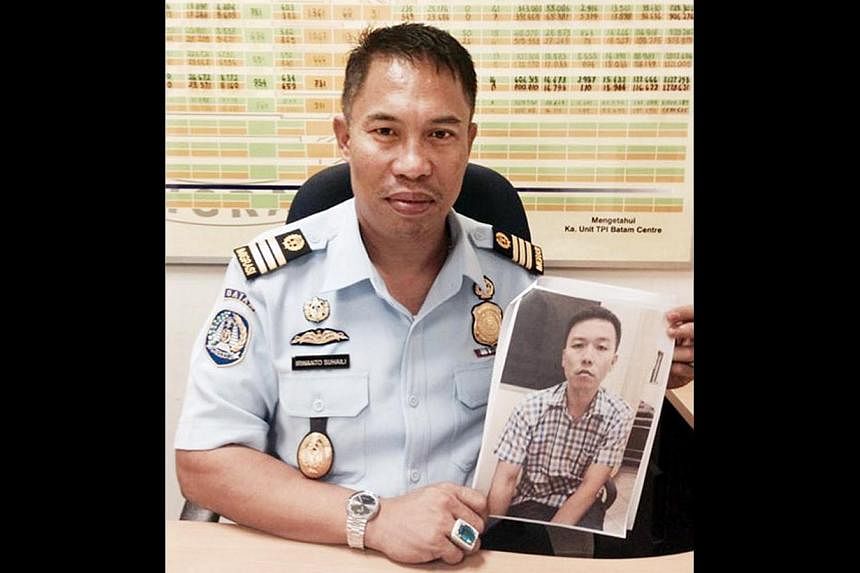 A Batam immigration officer showing a picture of Mr Lim Yong Nam, who was arrested at Batam Centre ferry terminal on Oct 23. The businessman is wanted by the US for breaching a US trade embargo against Iran.