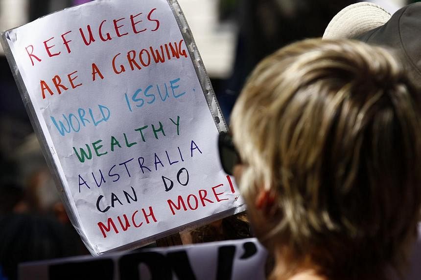 Protesters hold placards at the 'Stand up for Refugees' rally held in central Sydney, Australia on Oct 11, 2014. -- PHOTO: REUTERS