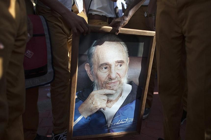 Students hold a portrait of former Cuban president Fidel Castro, during a march "For the Five and Against the Terrorism" in Havana on Sept 30, 2014. -- PHOTO: REUTERS
