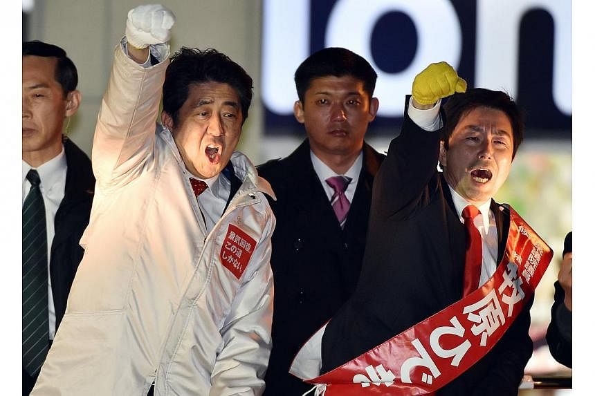 Japanese Prime Minister and ruling Liberal Democratic Party (LDP) leader Shinzo Abe (left) and his his party candidate Hideki Makihara (right). The LDP is set to sweep elections this weekend. -- PHOTO: AFP