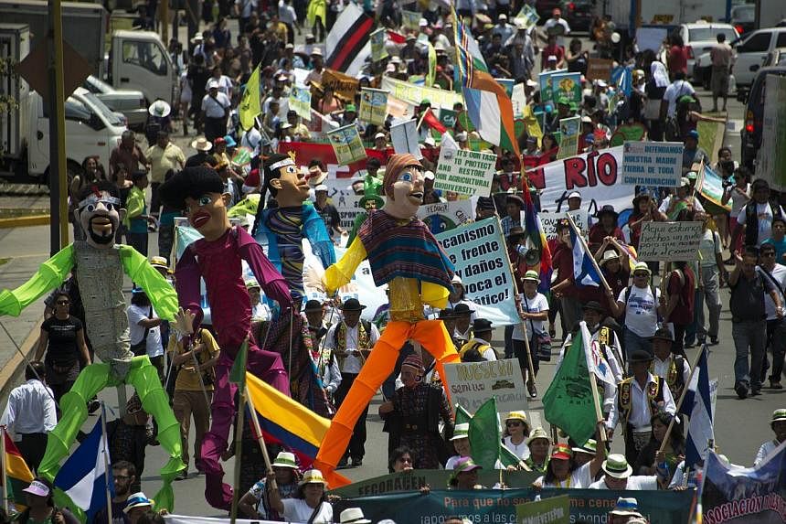 Thousands participate in the People’s Climate March on the sidelines of the UN COP20 and CMP10 climate change conferences being held in Lima on Dec 10, 2014. -- PHOTO: AFP