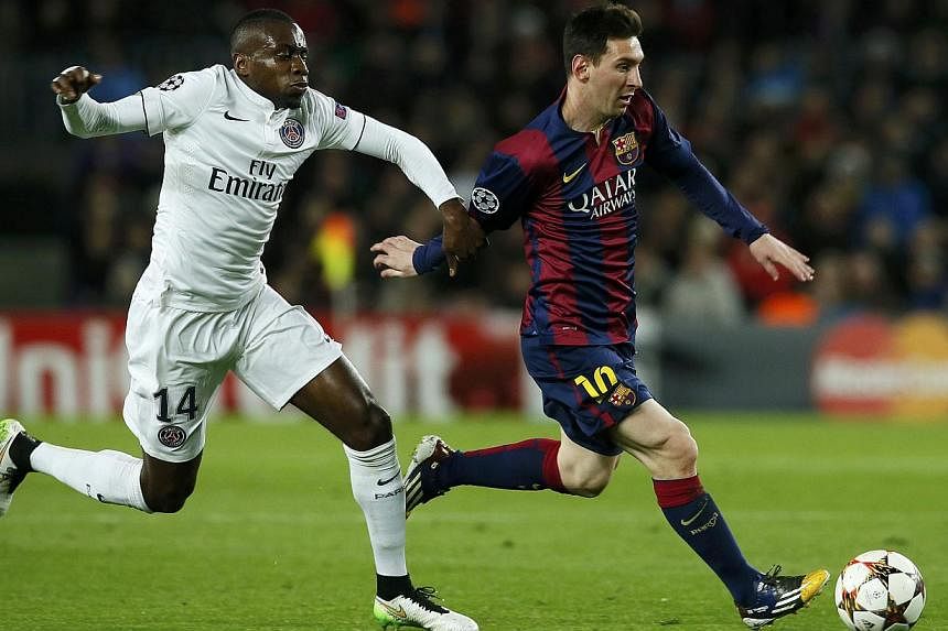 Barcelona's Lionel Messi (right) is challenged by Paris St Germain's Blaise Matuidi during their Champions League Group F soccer match at the Nou Camp stadium in Barcelona, Dec 10, 2014. Messi's goal that brought Barcelona level with Paris Saint-Germ