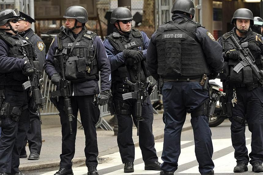 In this March 16, 2013 file photo heavily armed New York Police Department (NYPD) officers look on as parade participants make their way up 5th Avenue during the 252th New York City St. Patrick's Day Parade. -- PHOTO: AFP&nbsp;