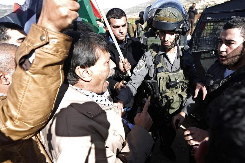 Palestinian minister Ziad Abu Ein (centre) argues with Israeli border policemen during a protest near the West Bank city of Ramallah Dec 10, 2014. EU foreign affairs head Federica Mogherini demanded an "immediate" inquiry Wednesday into the death of 