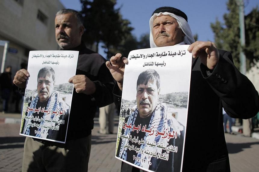 People hold posters of Palestinian minister Ziad Abu Ein at a hospital in the West Bank city of Ramallah Dec 10, 2014.&nbsp;Israeli Defence Minister Moshe Yaalon expressed regret for the death on Wednesday of a senior Palestinian official after a con