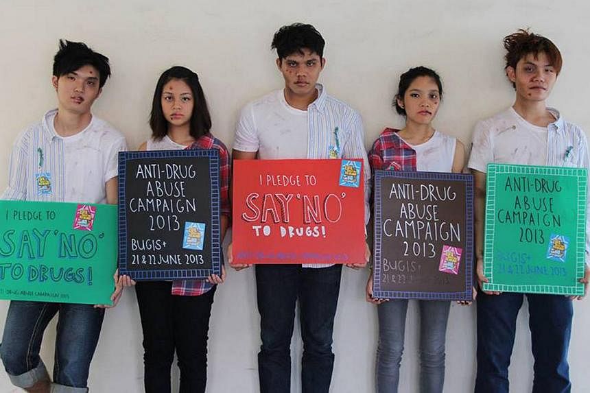 Singapore Polytechnic students dressed in a combination outfit of a regular person and a drug addict for a publicity event during the Anti-Drug Abuse Campaign in 2013. -- PHOTO: CENTRAL NARCOTICS BUREAU&nbsp;