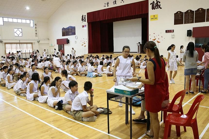 Kong Hwa School pupils collecting their PSLE results. The secondary school posting results will be released next Friday, Dec 19, the Ministry of Education (MOE) said Friday. -- PHOTO: ST FILE&nbsp;