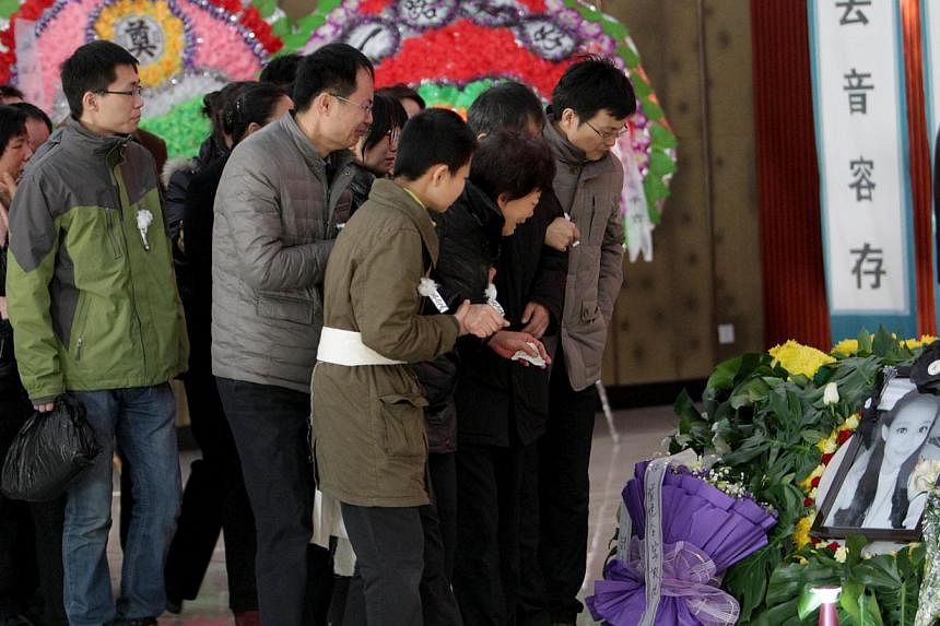 Family members and friends mourn during the funeral ceremony of Qiu Yuanyuan, a Chinese television presenter who died of cancer, in Zhengzhou, north China's Henan province on Dec 12, 2014. -- PHOTO: AFP