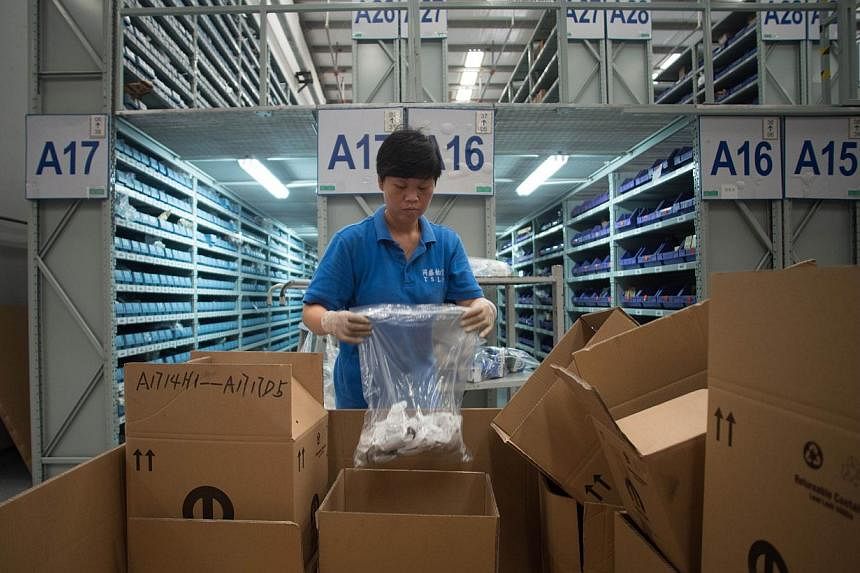 This picture taken on Sept 24, 2014, shows workers packing goods at a warehouse of TSLP at the China (Shanghai) Pilot Free Trade zone during a media trip.&nbsp;China is to launch three pilot free trade zones (FTZ) in the government's push for greater