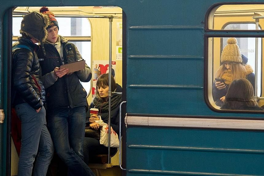 Commuters consulting their electronic connected devices inside a train coach in the Moscow Metro on Dec 1, 2014.&nbsp;Moscow's metro said on Friday it was carrying out emergency checks of its system after a young couple made their way into a tunnel a
