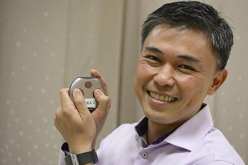 The Reka medical device in cardiologist Lim Toon Wei's hands allows patients to be monitored for longer periods.
