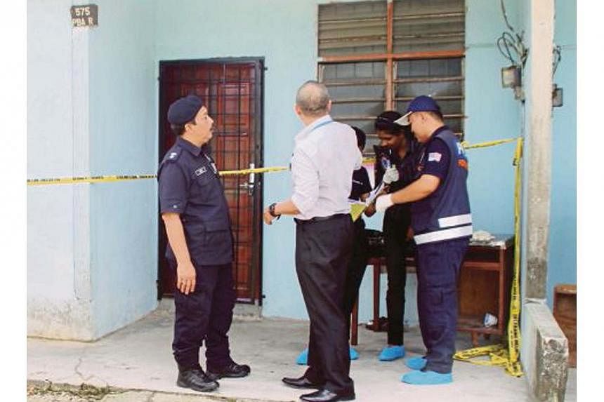 Police investigators outside the longhouse unit in Kampung Pisang in the Machang Bubok area on mainland Penang where Myanmar nationals were murdered and dismembered in brutal killings. -- PHOTO: NSTP