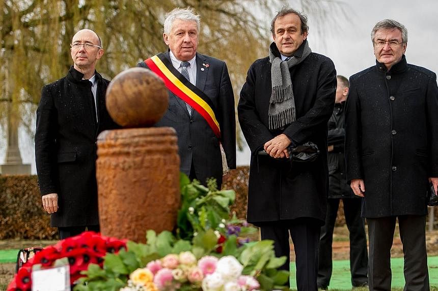 A hundred years after the famous World War I "Christmas Truce," UEFA chief Michel Platini (third from left) unveiled a memorial Thursday to the football match British and German soldiers played in no man's land as the guns fell silent. -- PHOTO: AFP