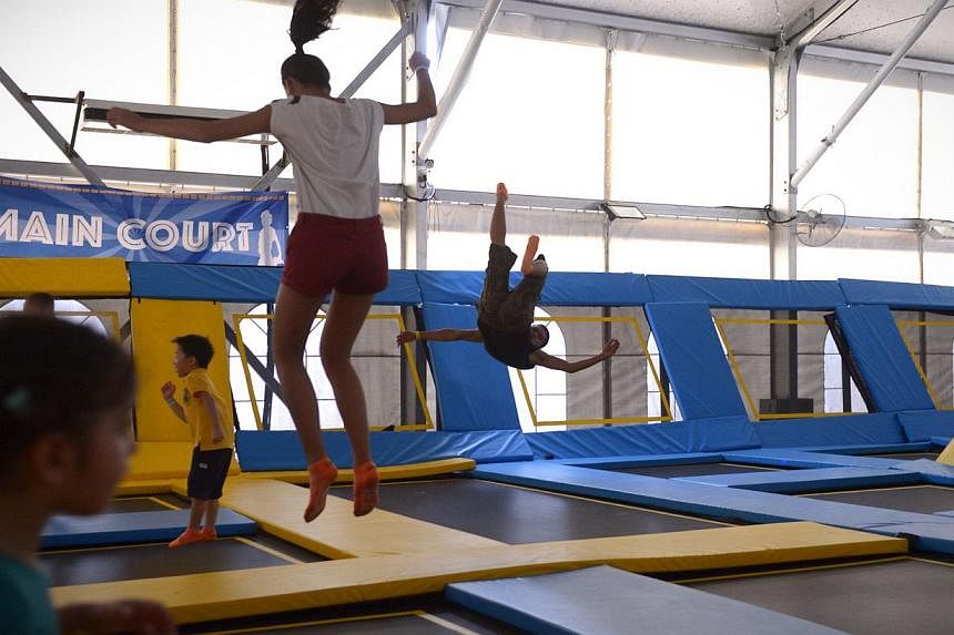 Visitors jump on trampolines at the main court at the newly opened Zoom Park on Dec 13, 2014. -- ST PHOTO: MARK CHEONG