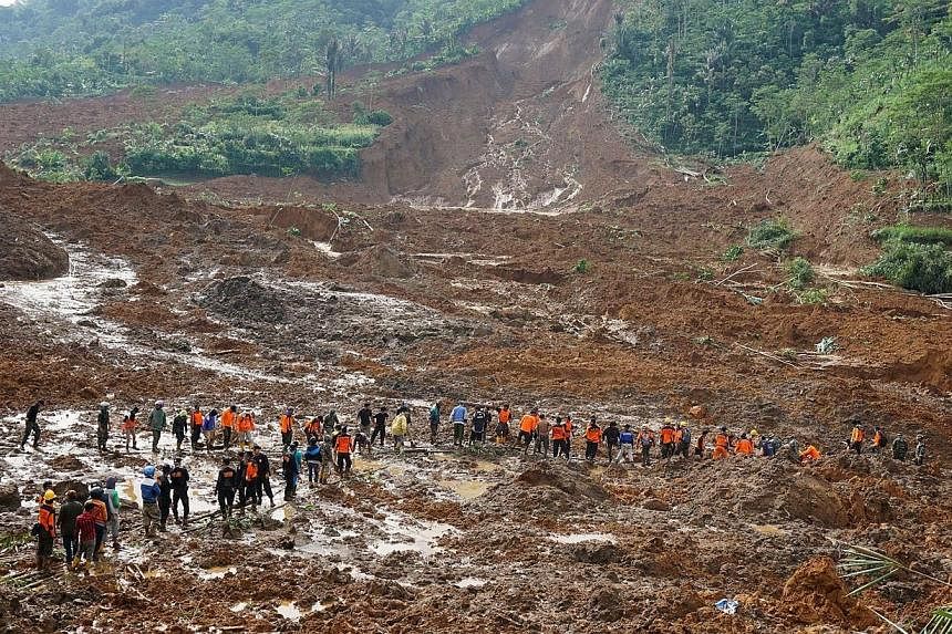 A rescue team remove victims bodies of a landslide triggered by torrential downpours at Jemblung village in Banjarnegara, Central Java province on Saturday, Dec 13, 2014.&nbsp;At least 17 people were killed and nearly 100 others left missing in the l