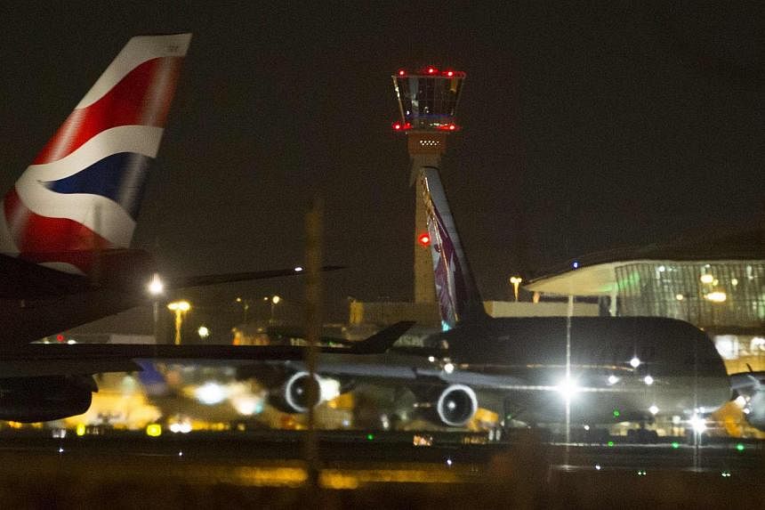 Aircraft taxi next to the control tower at Heathrow airport in London on Dec 12, 2014. -- PHOTO: REUTERS