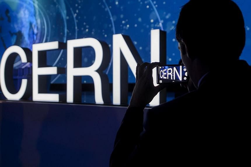 A guest takes a picture of the European Organisation for Nuclear Research (Cern) logo during an official ceremony marking the 60th anniversary of Cern in Meyrin near Geneva on Sept 29, 2014.&nbsp;Cern's Large Hadron Collider will be turned back on in