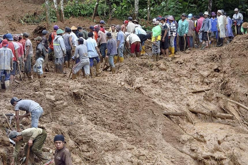 Villagers using shovels to remove mud from the main road at Pasuruhan village in Wonosobo Dec 12, 2014, in this photo taken by Antara Foto. Heavy rain caused a landslide early Friday in Pasuruhan village, with a citizen killed when a 50m-high cliff h