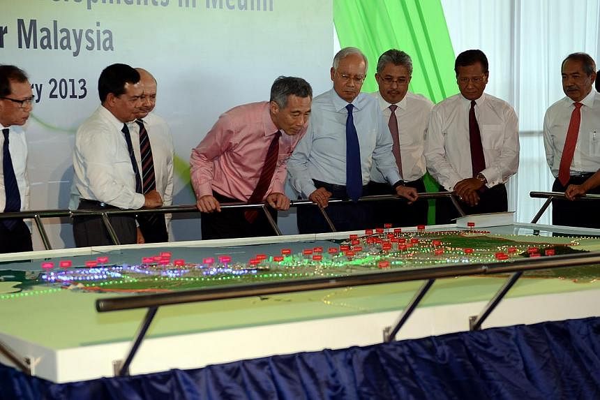 Singapore Prime Minister Lee Hsien loong (in pink) and his Malaysian counterpart Datuk Seri Najib Tun Razak (fourth from right) looking at a model of the Medini Integrated Wellness Capital in Nusajaya, Iskandar Malaysia in this file picture. A high-s