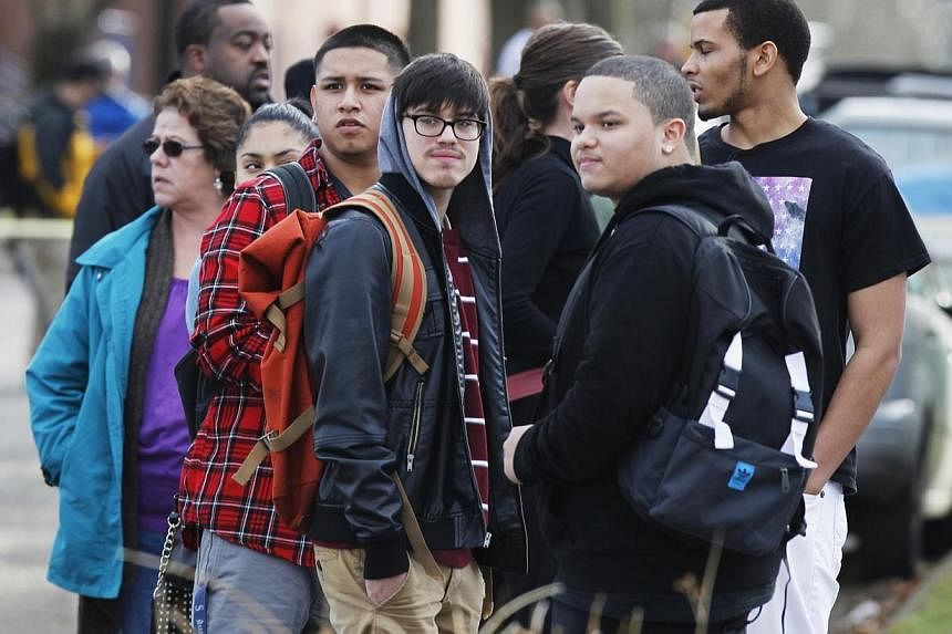 Students waiting for family members to pick them up outside the Rosemary Anderson High School in Portland, Oregon, on Dec 12, 2014. -- PHOTO: REUTERS