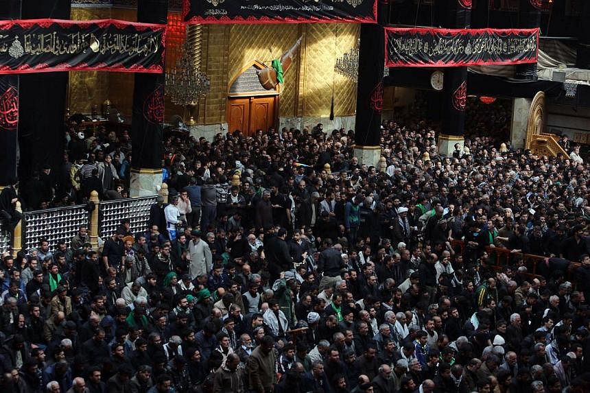 Iraqi Shi'ite Muslim pilgrims take part in Friday prayers at the shrine of Imam Abbas in Karbala on Dec 12, 2014.&nbsp;Millions of Shi'ite Muslim pilgrims defied the threat of extremist attacks and thronged the Iraqi shrine city for the climax of the
