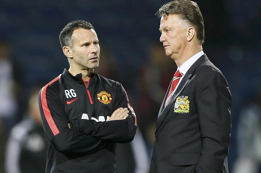 Manchester United manager Louis van Gaal (right) and assistant Ryan Giggs chat ahead of their team's English Premier League soccer match against West Bromwich Albion on Oct 20, 2014. Manchester United manager Louis van Gaal says he has sympathy for L
