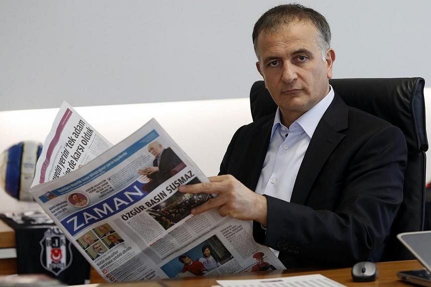 Zaman editor-in-chief Ekrem Dumanli holds a copy of his newspaper at the headquarters of Zaman daily newspaper in Istanbul on Sunday, Dec 14, 2014.&nbsp;Turkish police on Sunday detained the chief editor of a top newspaper as part of an ongoing opera
