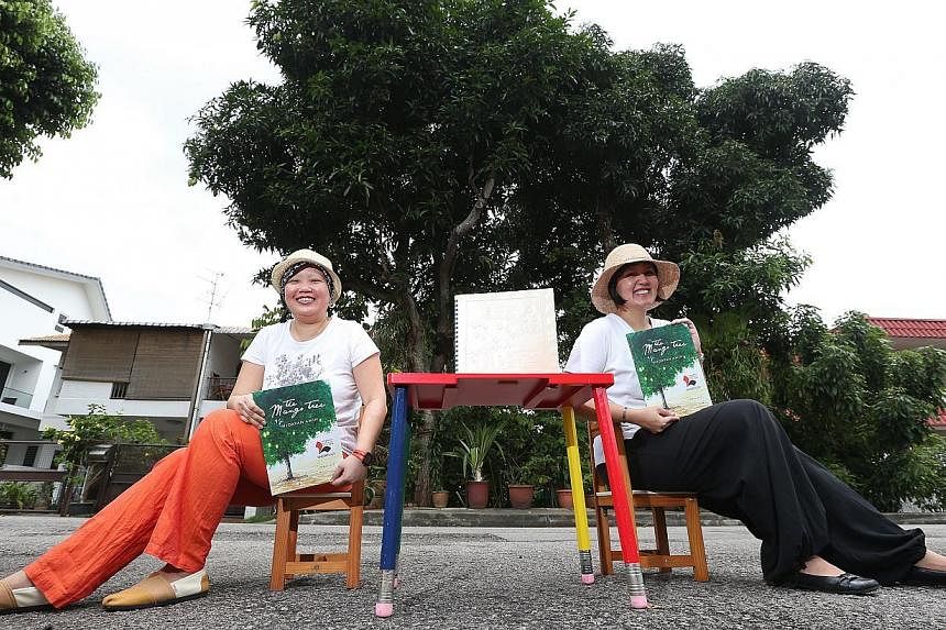 Local writers Lee Seow Ser (left) and Hidayah Amin, with the Braille and non-Braille versions of Ms Hidayah's The Mango Tree. The Braille version of the 32-page book for children has 10 pages, of which only one has illustrations. "If we had more mone