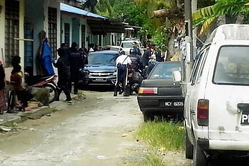Police at a house in Kampung Pisang, Cherok Tok Kun, where some of the grisly murders of Myanmar nationals took place. Police are now hunting for a fourth suspect believed to be behind the gruesome murders in Penang this year. -- PHOTO: THE MALAY MAI