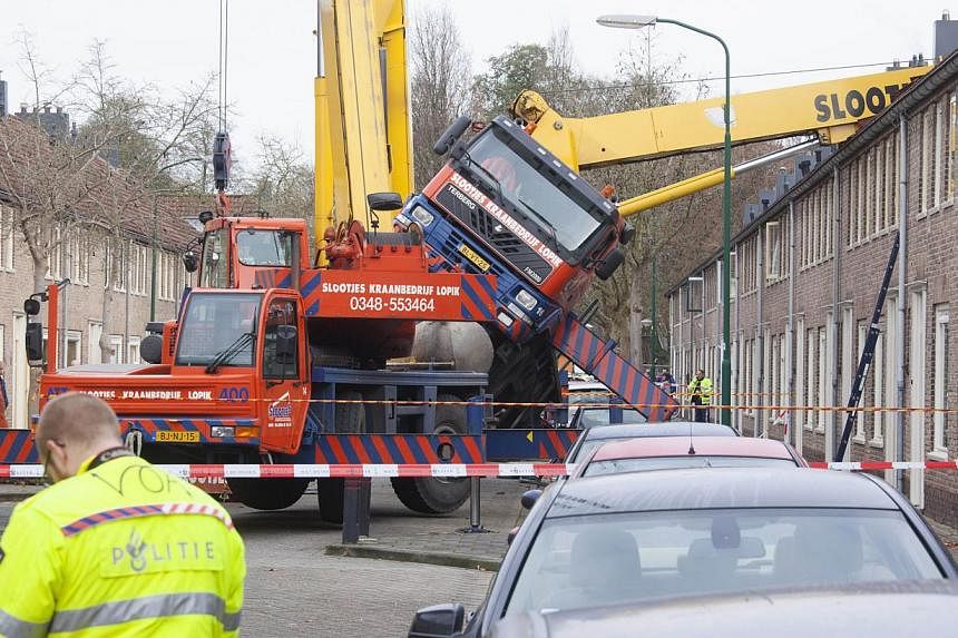 A picture taken on Dec 13, 2014 in IJsselstein shows a crane which fell down onto the roof of a house. The incident occurred when a man tried to surprise his girlfriend by proposing from the top of the crane, which then toppled on to the house, thoug