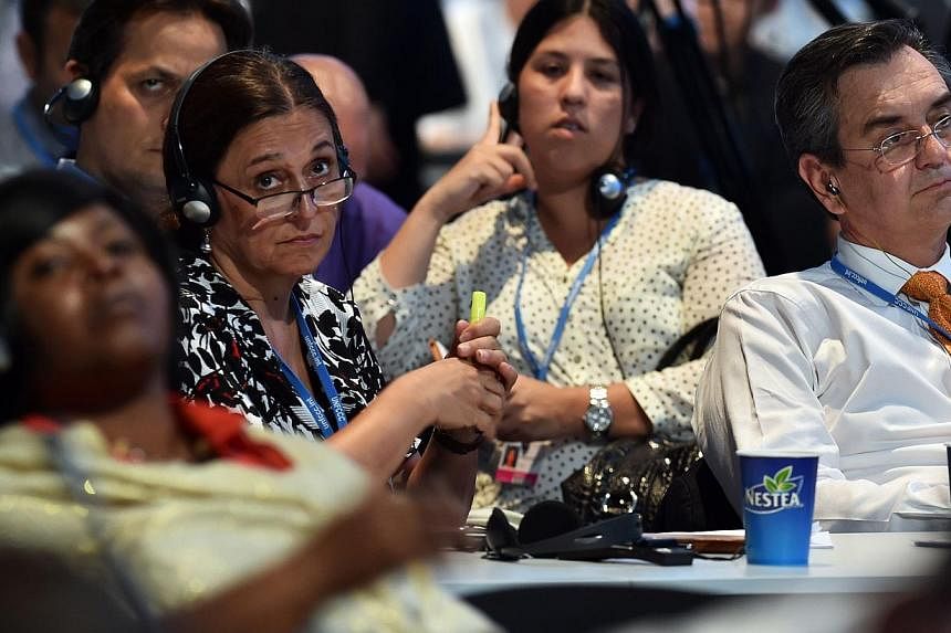 Members of representative commissions of the countries participating in the climate change conferences, attend the seventh plenary meeting of the COP20 on Dec 13, 2014 in Lima, as they continue working on a final document draft. -- PHOTO: AFP