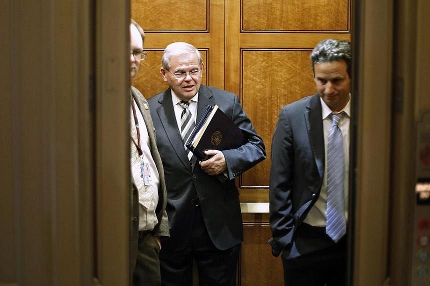 U.S. Senator Robert Menendez (center) and Senator Brian Schatz (right) board an elevator as they take a break from a long series of votes, many on procedural matters or to confirm members of the Obama administration, at the U.S. Capitol in Washington