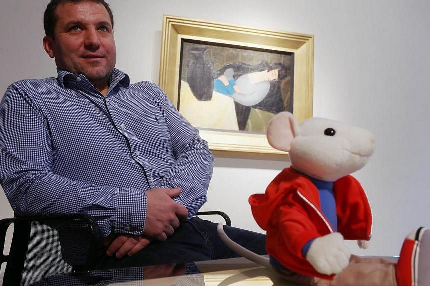 Hungarian art historian Gergely Barki poses next to a plush figure of the Stuart Little character in front of the painting &nbsp;"Sleeping Lady with Black Vase"&nbsp;in Budapest on Nov27, 2014. &nbsp;A long-lost avant-garde painting went under the au