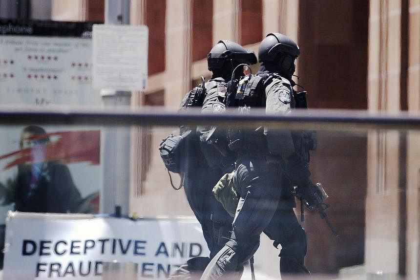 Police officers move in Martin Place near Lindt cafe, where hostages are being held, in central Sydney on Dec 15, 2014. -- PHOTO: REUTERS&nbsp;